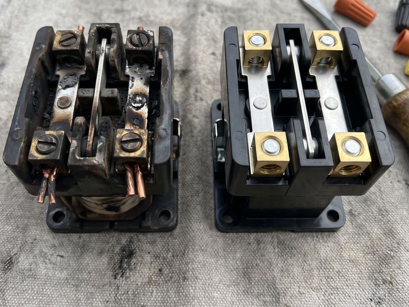 A contactor with burnt, pitted contacts beside a new one on a drop cloth